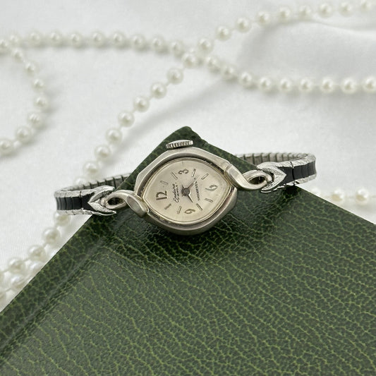 Vintage dainty silver tone Endura 17 jewels manual winding watch with silver and black stretchable band from the 1970's.