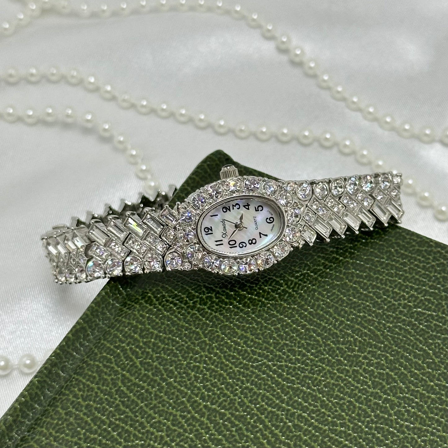 Vintage elegant rhinestone silver tone cocktail watch with mother of pearl oval dial and a bracelet encrusted with numerous crystals