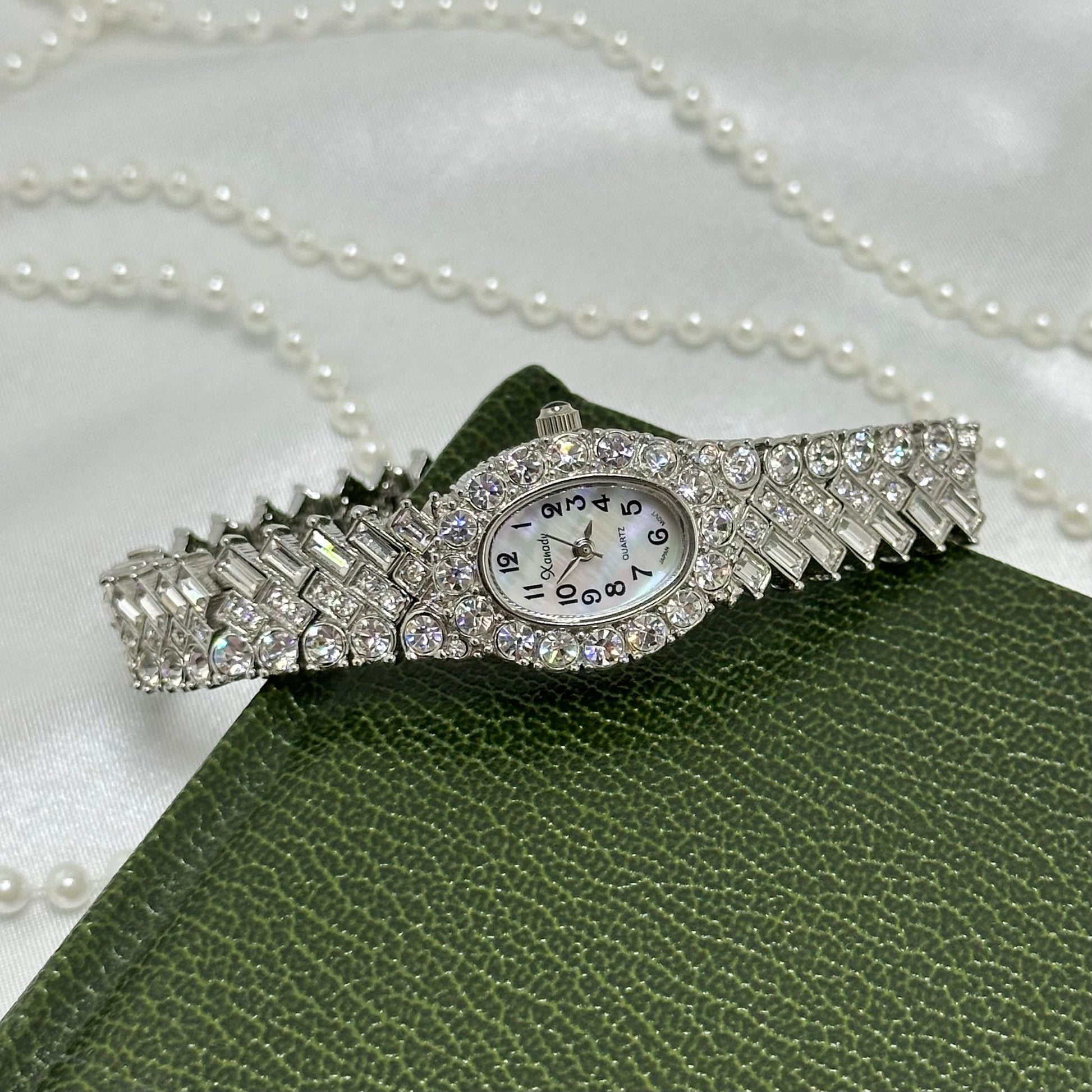 Vintage elegant rhinestone silver tone cocktail watch with mother of pearl oval dial and a bracelet encrusted with numerous crystals
