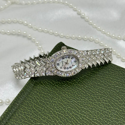 Vintage elegant rhinestone silver tone cocktail watch with mother of pearl oval dial and a bracelet encrusted with numerous crystals