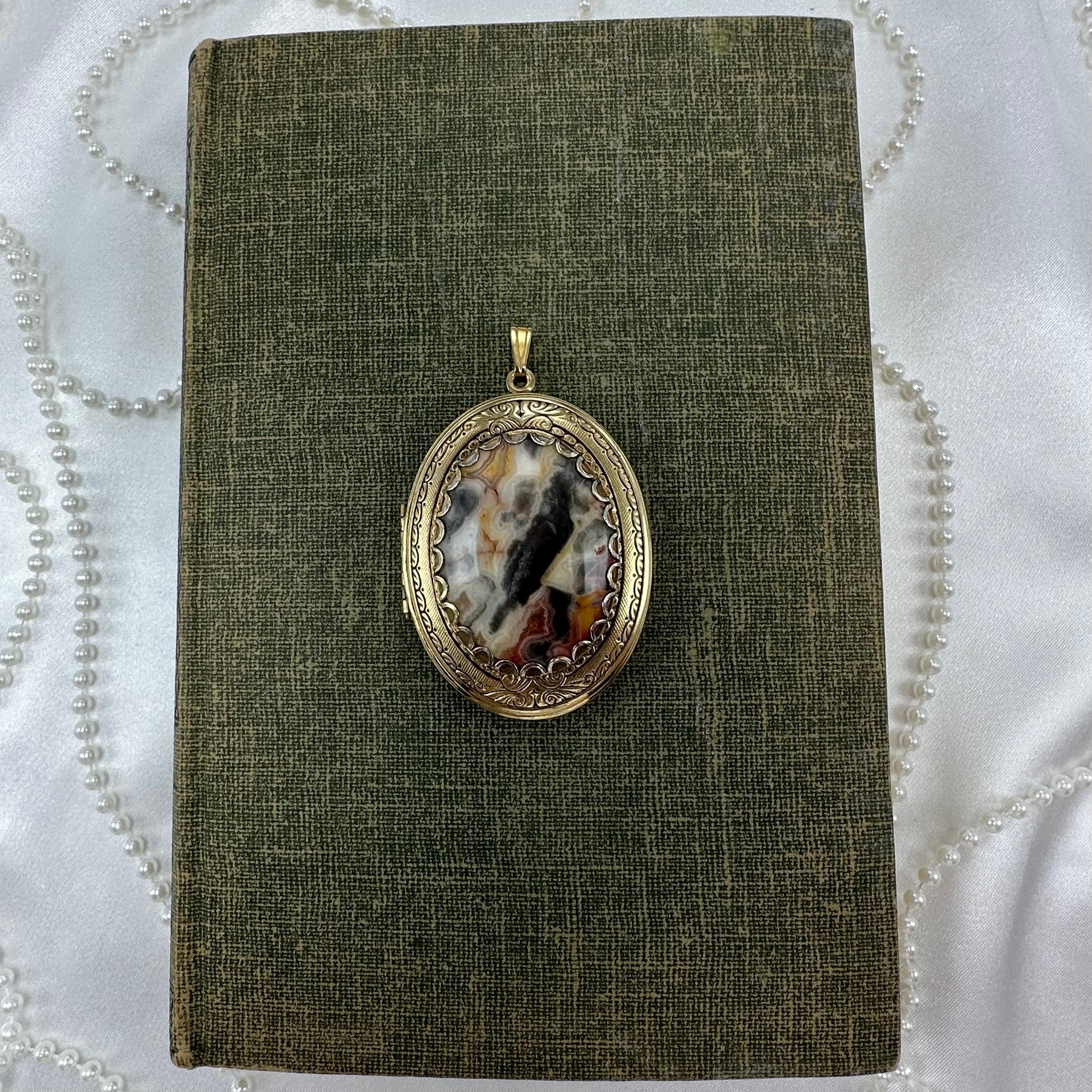 Vintage filigree oval hanging photo locket with gorgeous multicolor stone.