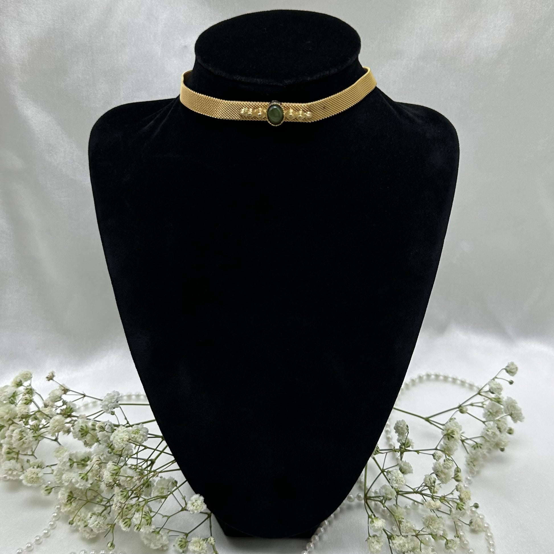Vintage gold choker necklace with green stone and hook clasp. There is a small dot of discoloration