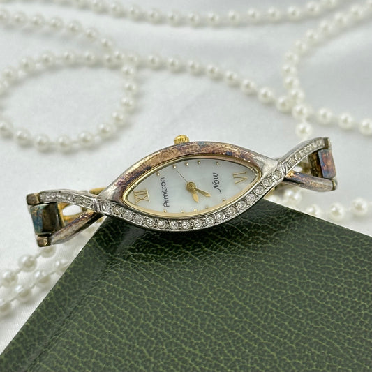 Vintage gold tone Armitron Now watch with marquise shaped bezel with crystals and a mother of pearl dial.