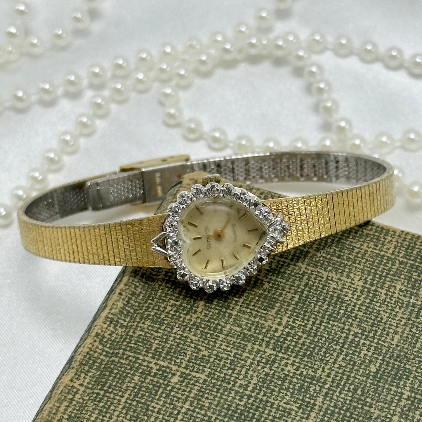 Vintage gold tone Armitron watch with heart shaped dial and diamanté bezel. Crystal is foggy.