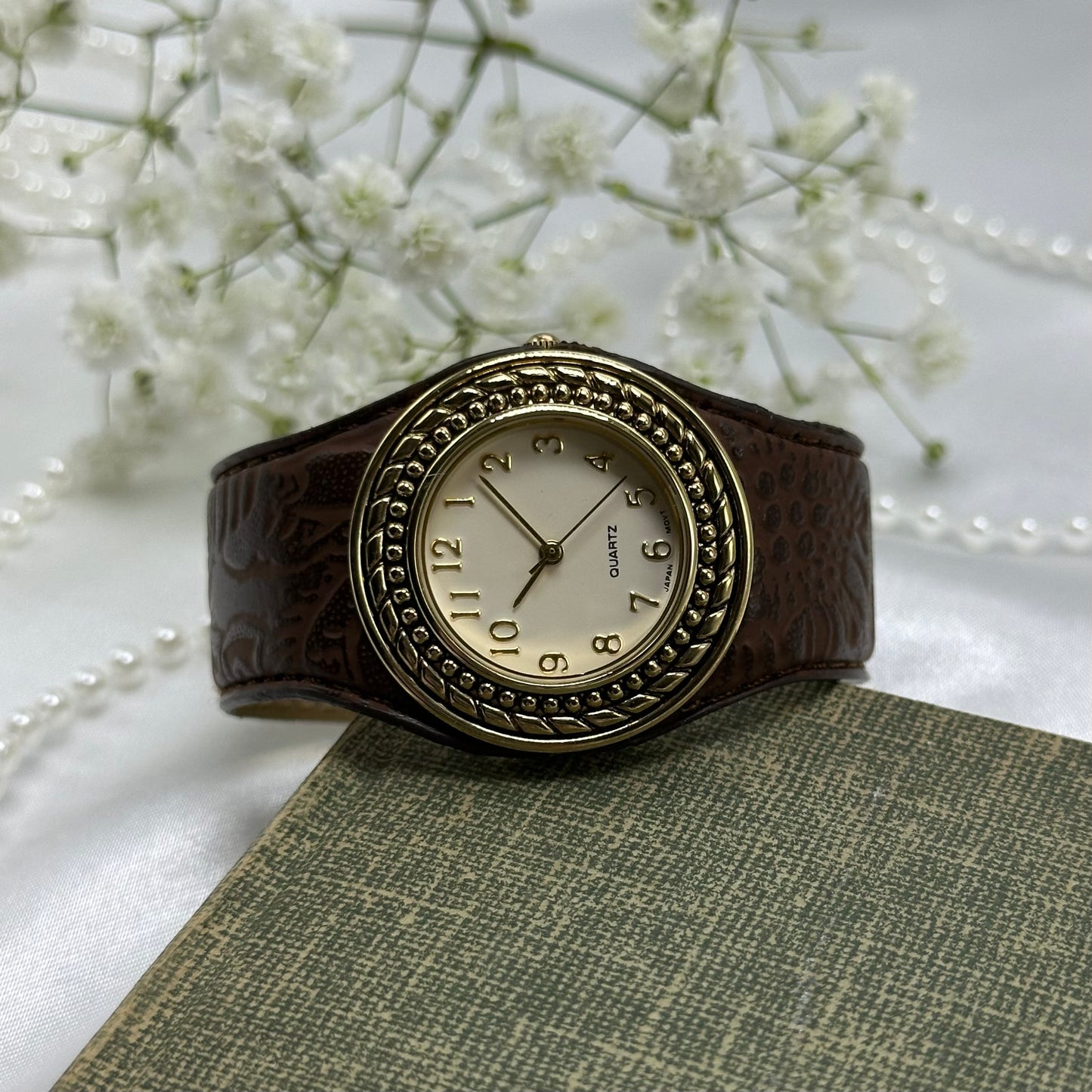 Vintage gold tone Avon cuff watch with brown leather band