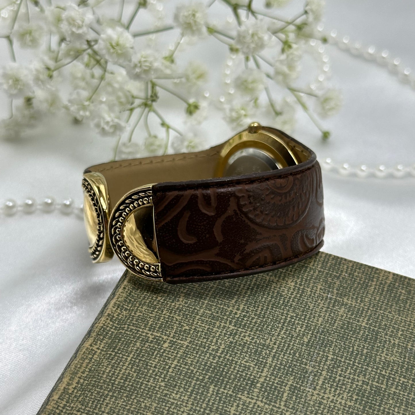 Vintage gold tone Avon cuff watch with brown leather band and quartz