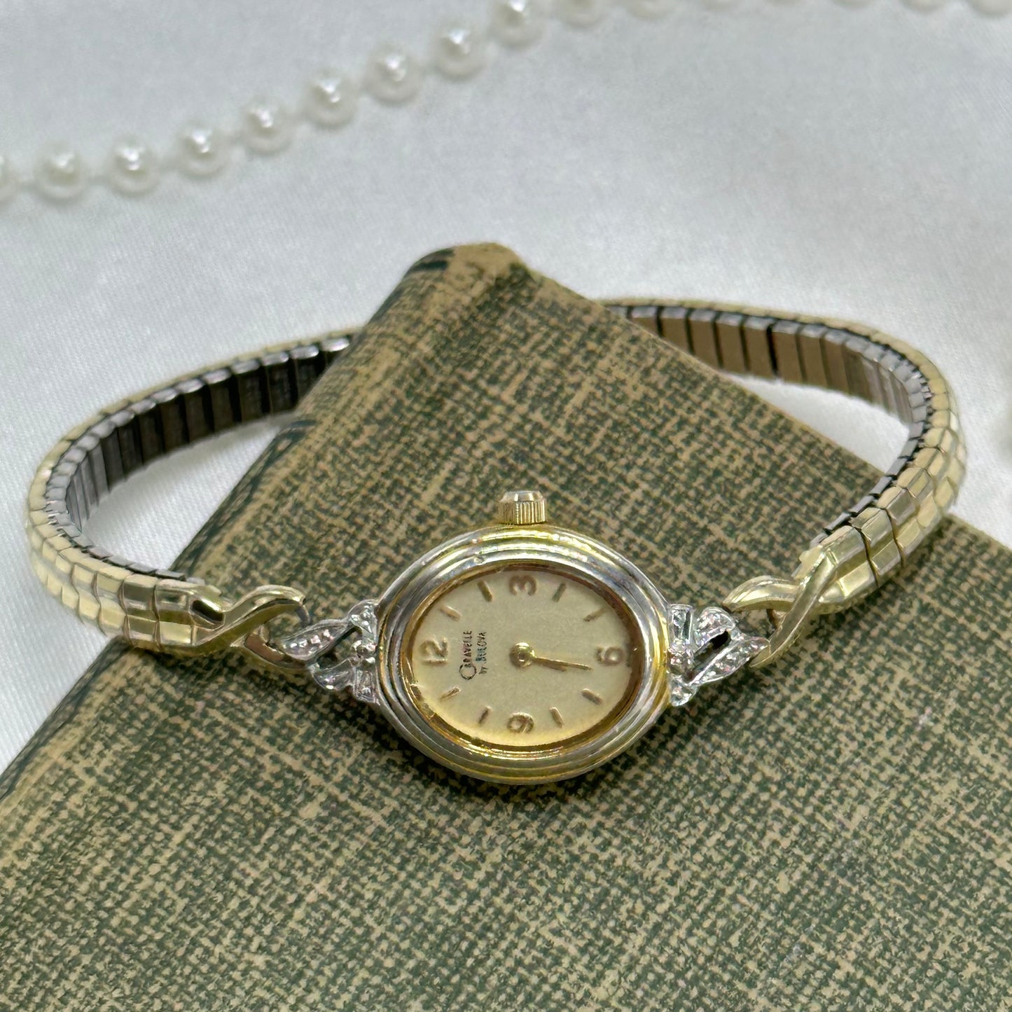 Vintage gold tone Caravelle by Bulova diamanté watch with thin stretchable band and quartz movement.