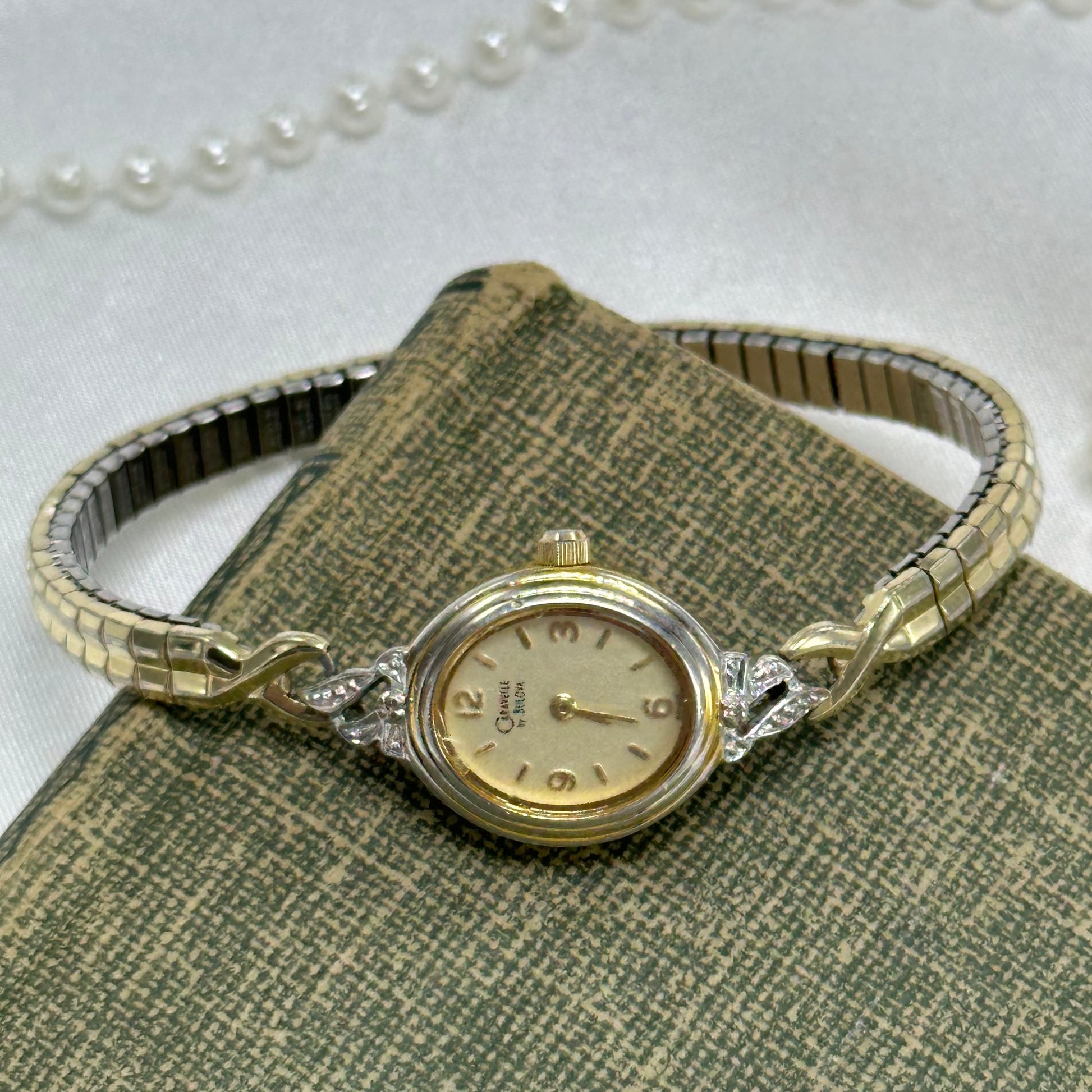 Vintage gold tone Caravelle by Bulova diamanté watch with thin stretchable band and quartz movement.