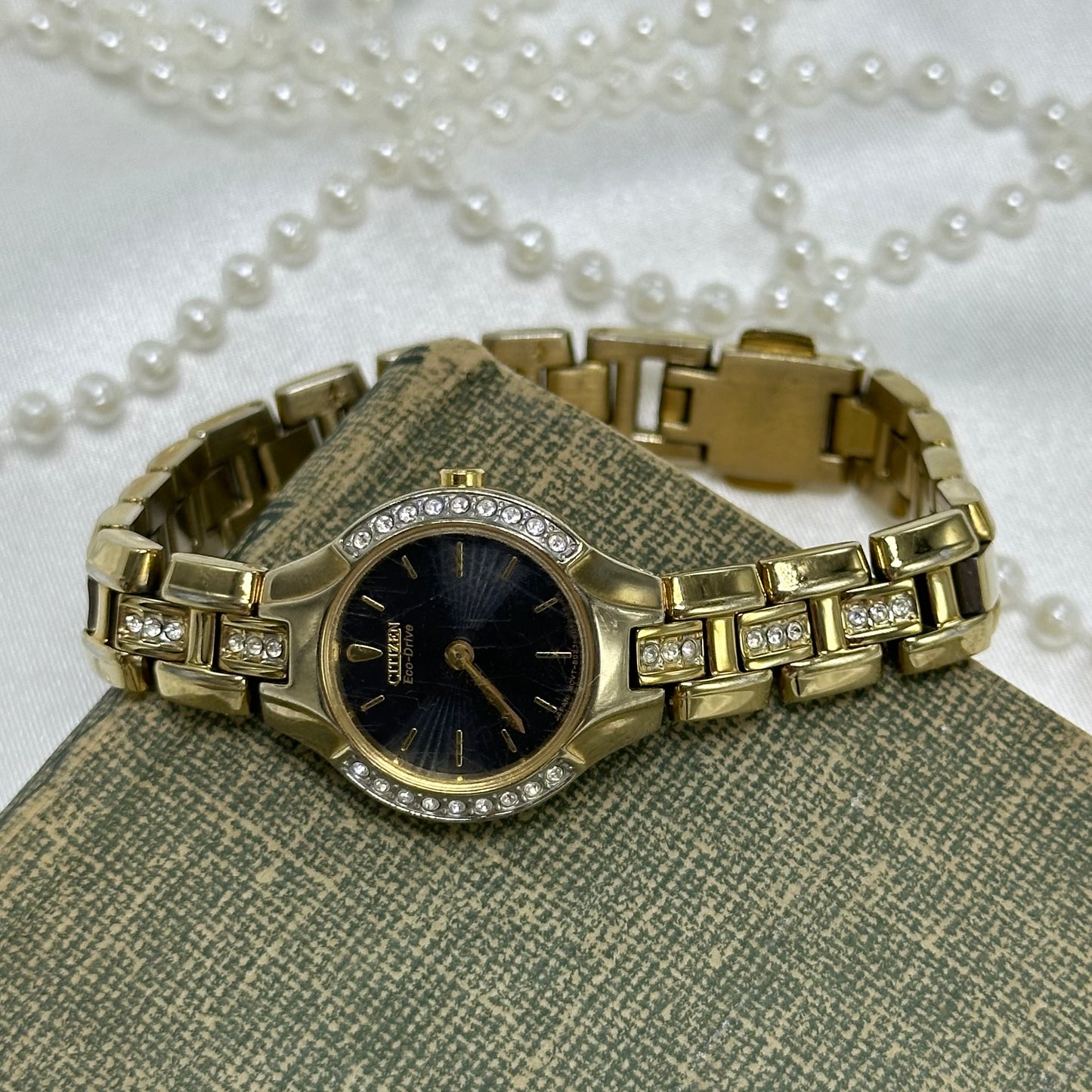 Vintage gold tone Citizen EcoDrive watch with diamanté round black dial and diamanté band.