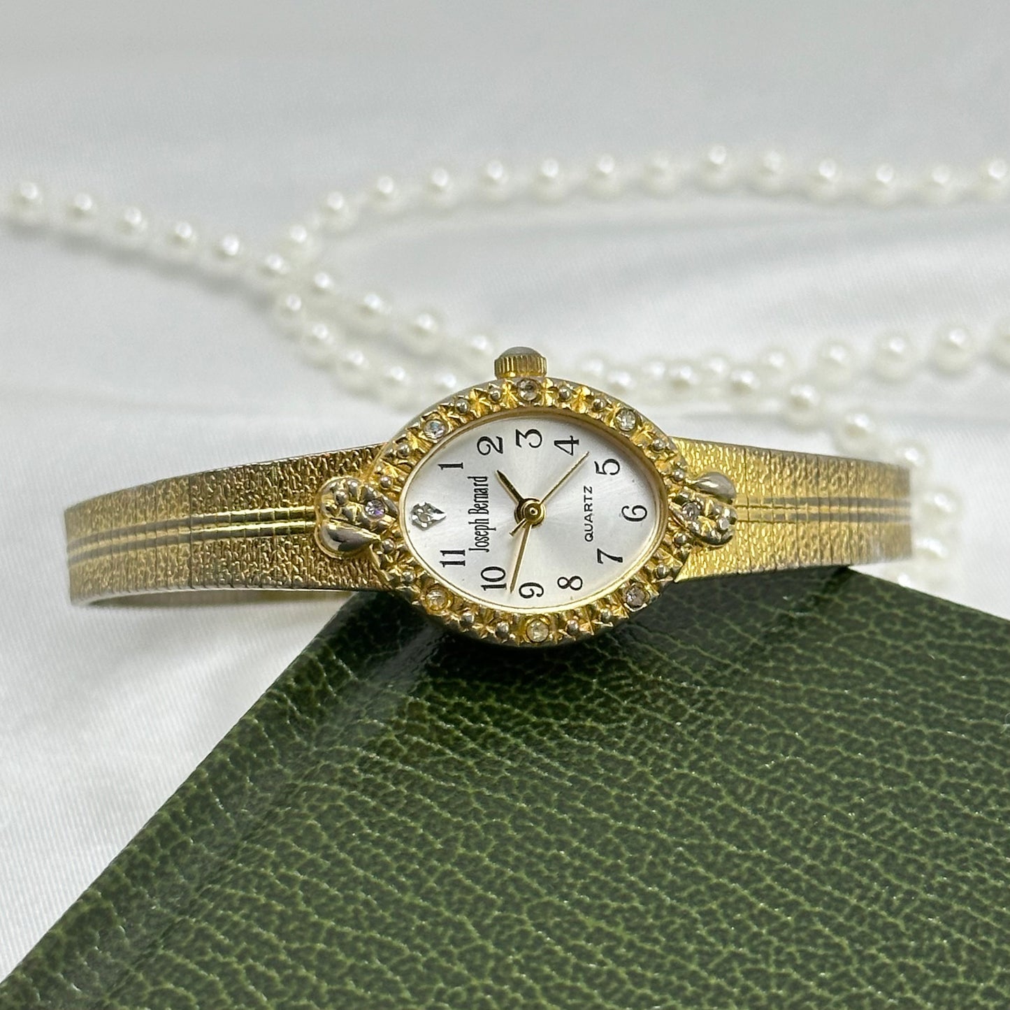 Vintage gold tone Joseph Bernard oval dial watch with gorgeous textured band and diamanté hearts bezel.