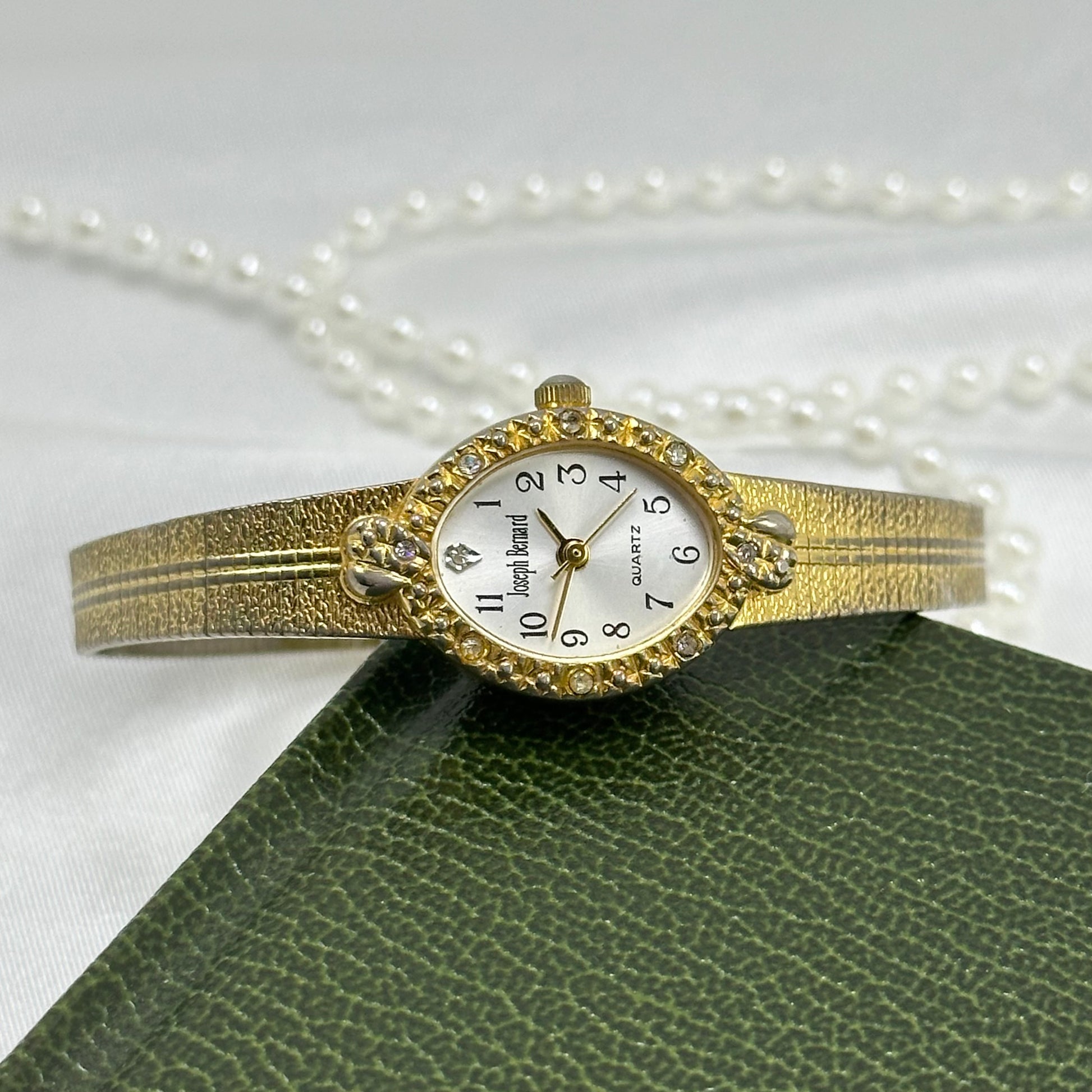 Vintage gold tone Joseph Bernard oval dial watch with gorgeous textured band and diamanté hearts bezel.