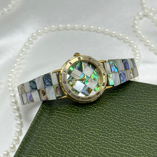 Vintage gold tone LA Express watch with round checkered abalone dial, roman numeral markers, and stretchable band.