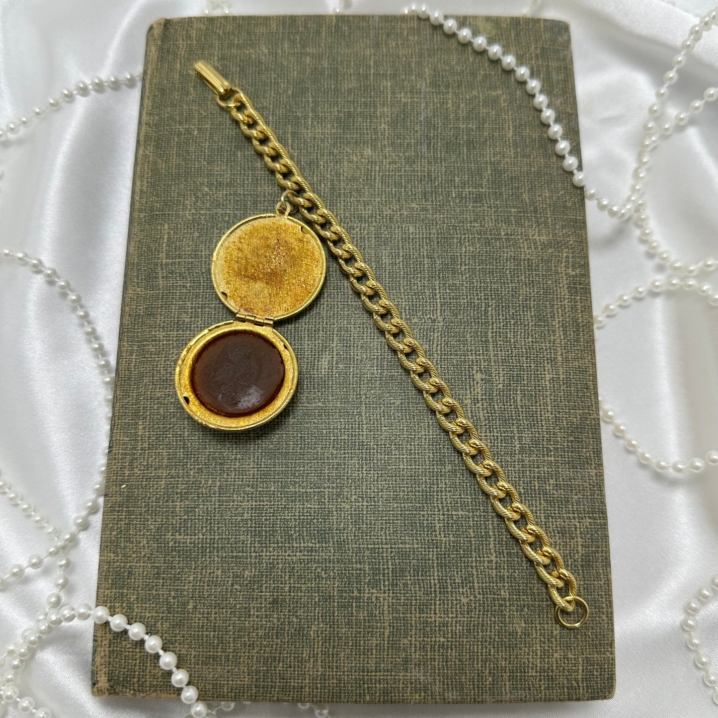 Vintage gold tone chain bracelet with detailed engraved perfume locket. Includes the original perfume inside. Most likely from the 60's or 70's.