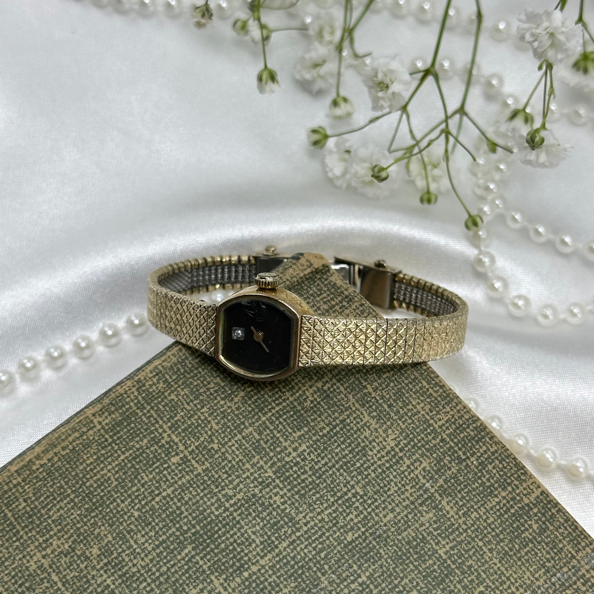 Vintage gold tone dainty watch with black dial
