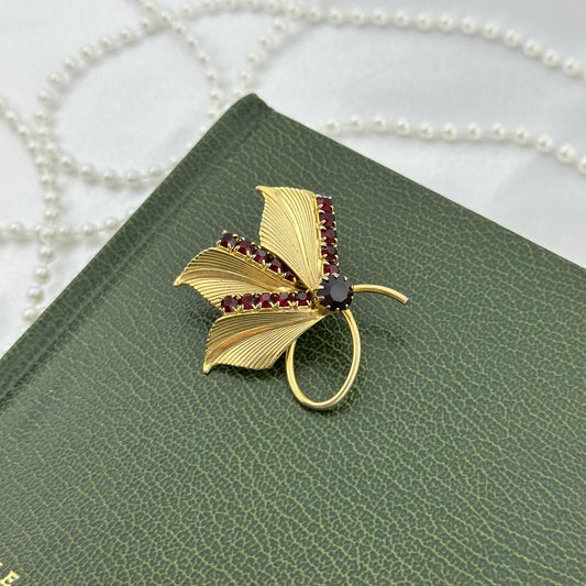 Vintage gold tone leaf brooch pin with red stones.