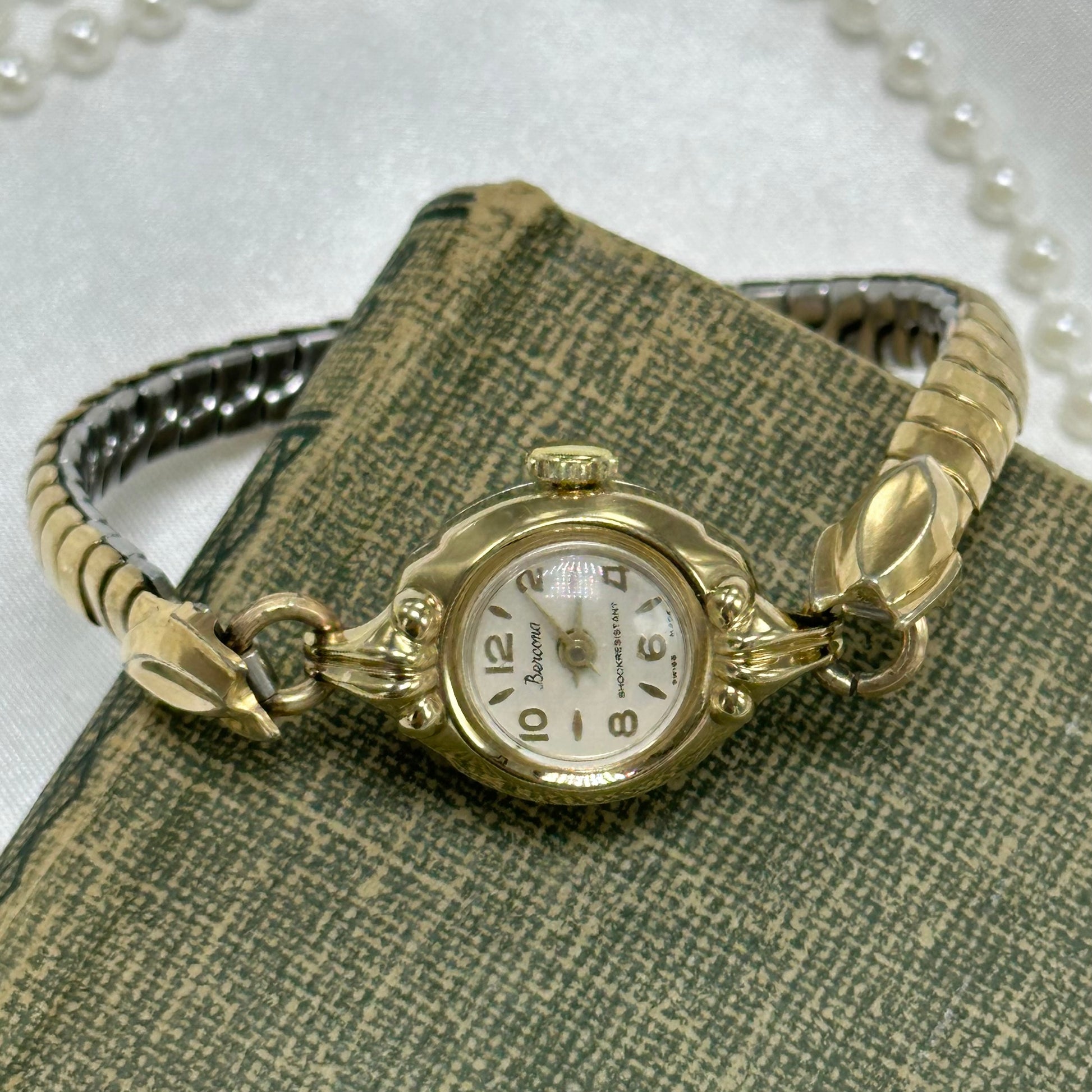 Vintage gold tone manual winding Bercona shock resistant Swiss made watch with unique stretchable band and elegant round dial from the 1950's.