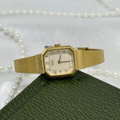 Vintage gold tone octagon dial Seiko watch with quartz movement and clasp band.