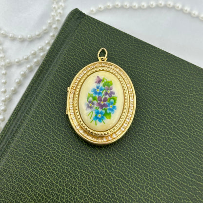 Vintage gold tone oval hanging photo locket by Avon with gorgeous blue and purple floral decal.