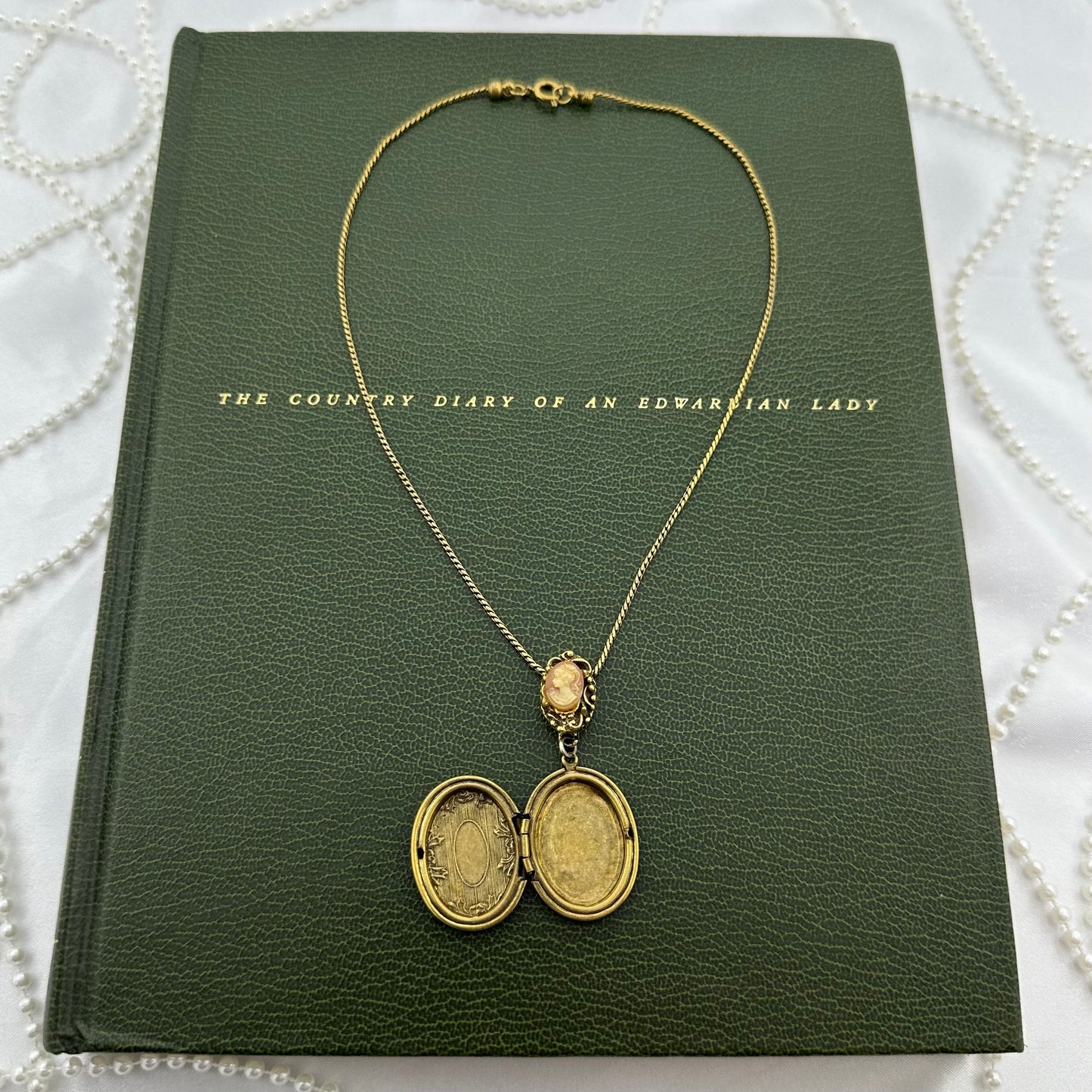 Vintage gold tone oval locket engraved filigree on vintage cameo necklace chain.