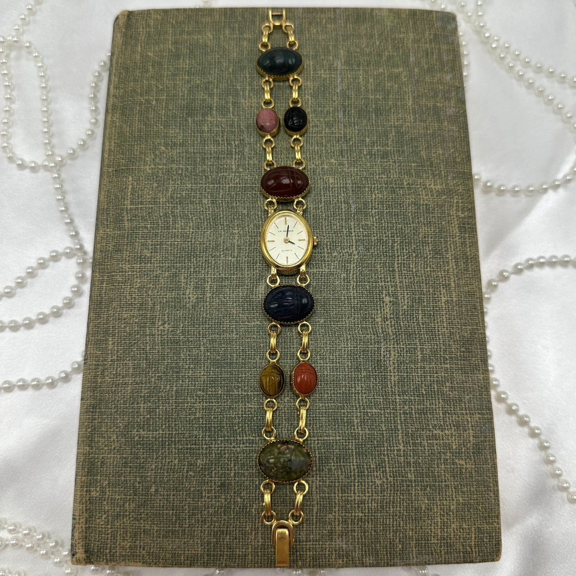 Vintage gold tone scarab watch with quartz movement.
