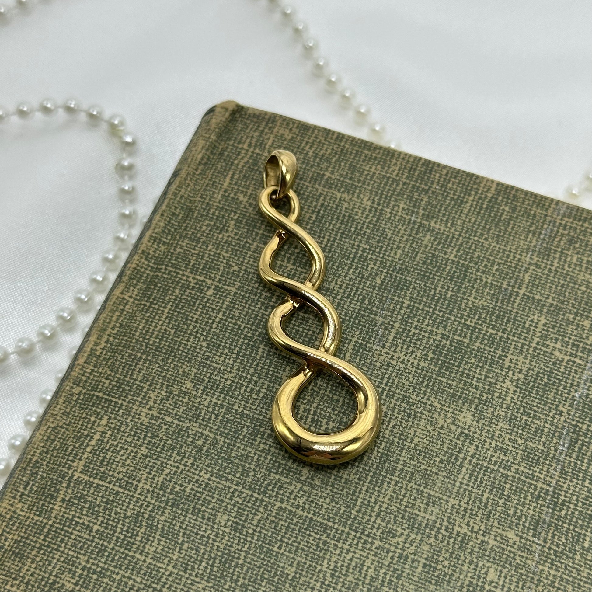 Vintage gold tone spiral charm pendant.
