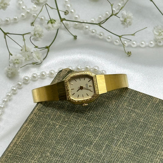 Vintage gold tone square dial Seiko watch with quartz movement and clasp band.