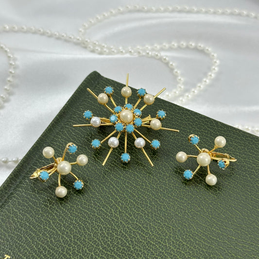 Vintage gold tone starburst brooch pin and clip on earring set with faux pearls and light blue stones.