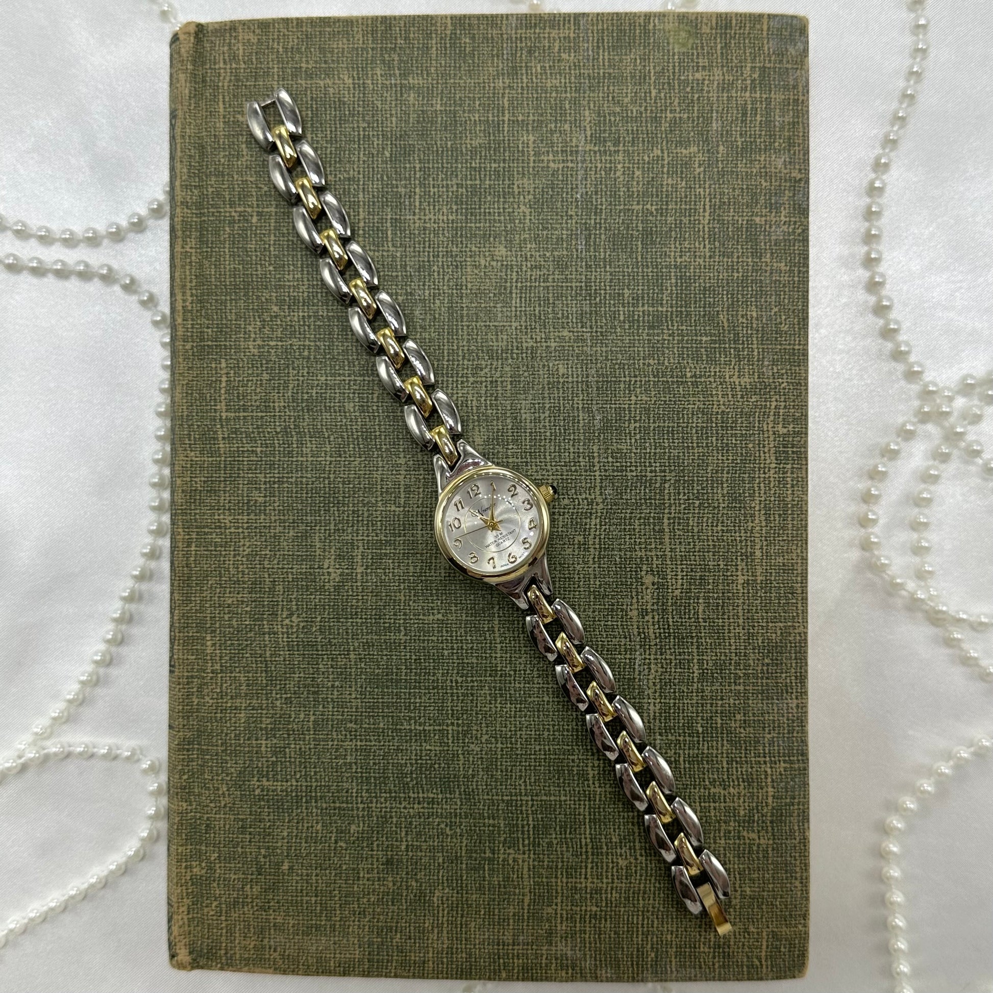 Vintage silver and gold tone Wrangler water resistant watch with blue jewel crown and quartz movement.