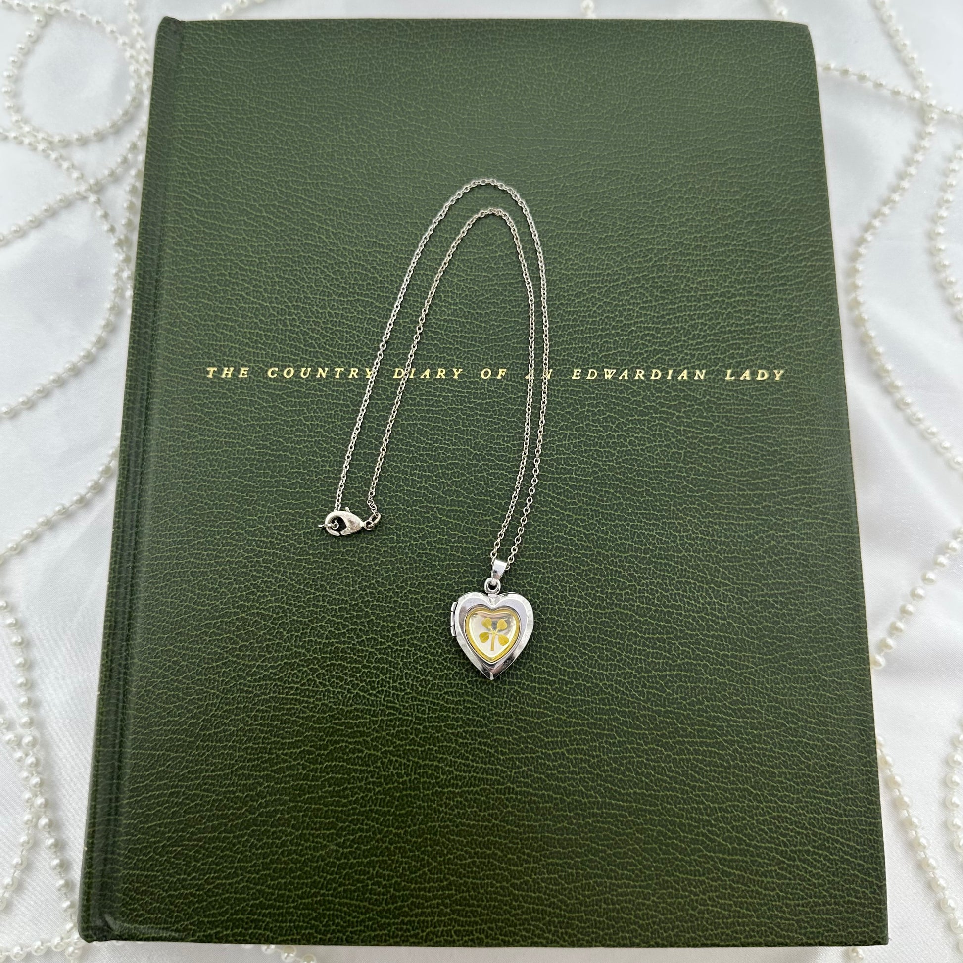 Vintage silver heart locket necklace with four leaf clover encased on the front. Marked 925.