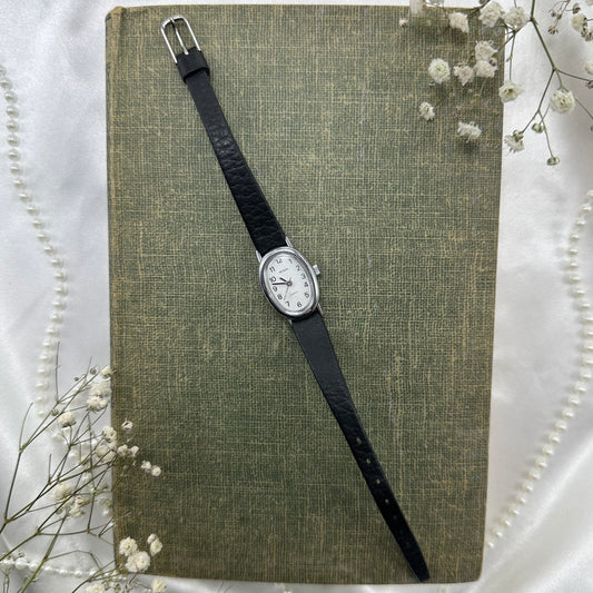 Vintage silver tone Acqua watch with slender black band and quartz movement.