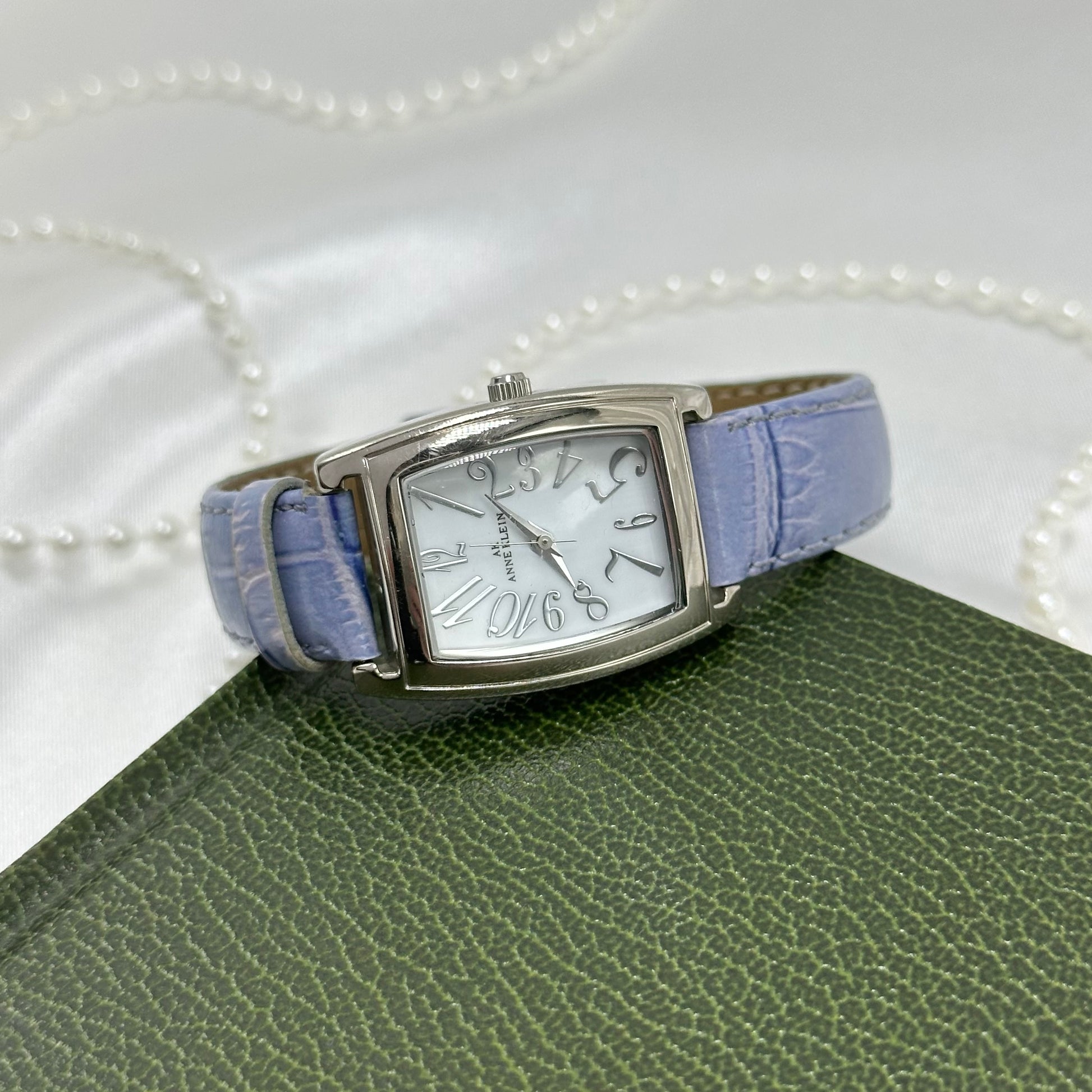 Vintage silver tone Anne Klein watch with rectangular dial and purple genuine leather band.