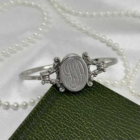 Vintage silver tone Avon 'Yesterday's Memories' hinged bangle bracelet with oval monogram locket.