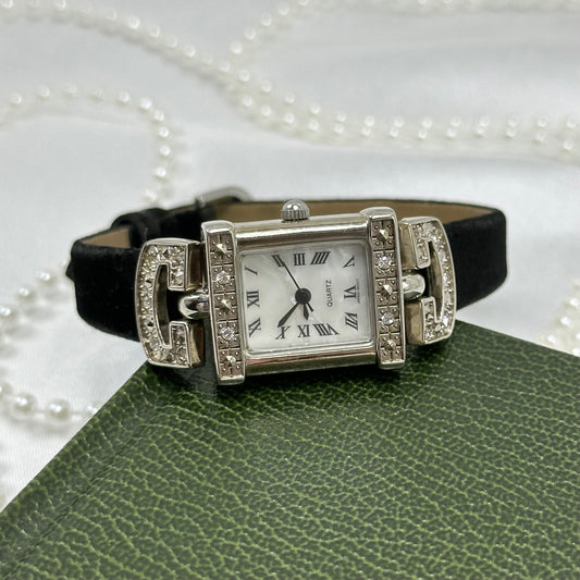 Vintage silver tone Avon watch with black velvet band and rectangular diamanté bezel.