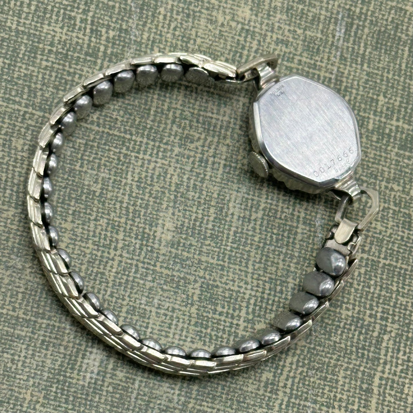 Vintage silver tone Bulova manual winding watch with gold hands and unique stretchable band from the 1950s. Watch comes with original BULOVA crown