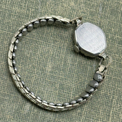 Vintage silver tone Bulova manual winding watch with gold hands and unique stretchable band from the 1950s. Watch comes with original BULOVA crown