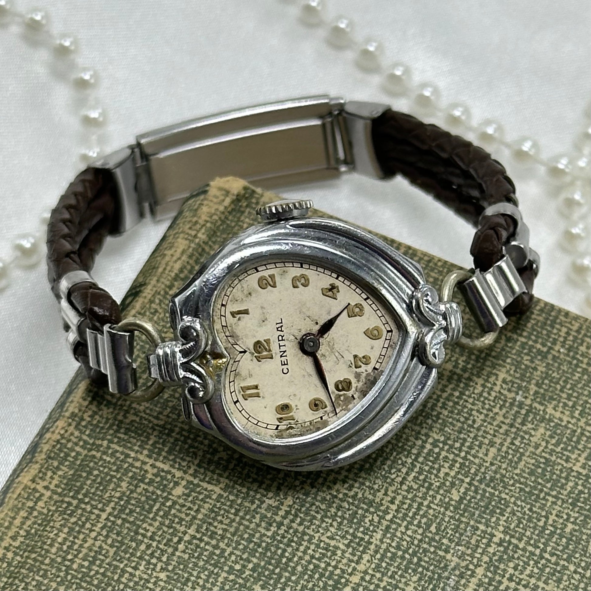 Vintage silver tone Central manual winding watch with gold numbers and brown leather 3 strand braided band.