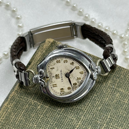 Vintage silver tone Central manual winding watch with gold numbers and brown leather 3 strand braided band.