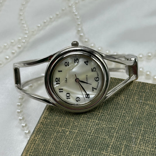 Vintage silver tone Collezio cuff watch with mother of pearl dial and quartz movement.