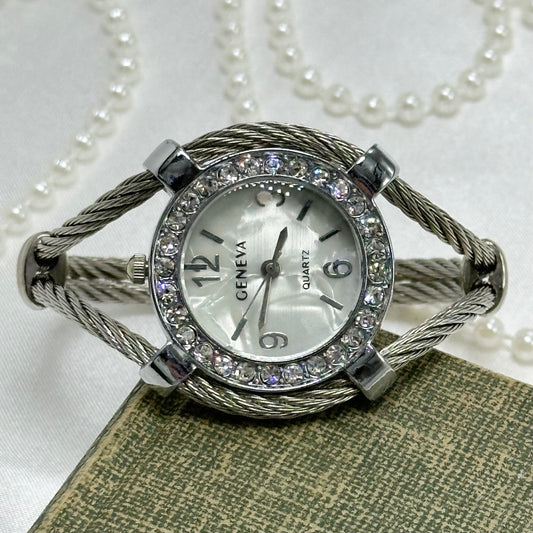 Vintage silver tone Geneva cuff watch with braided rope band and diamanté mother of pearl dial.