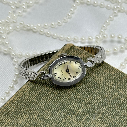 Vintage silver tone Timex manual winding cocktail watch with detailed stretchable band.