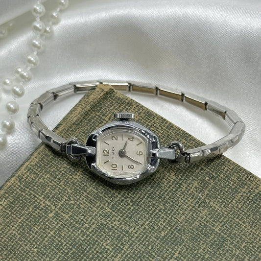 Vintage silver tone Timex manual winding watch with stretchable band.