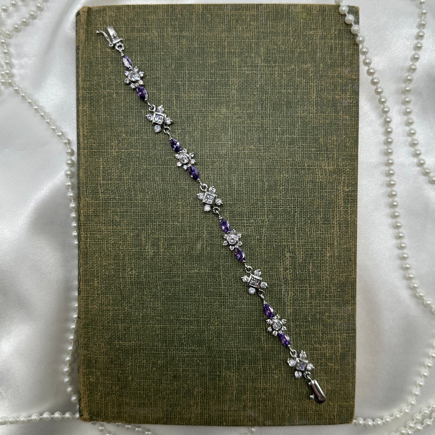 Vintage silver tone bracelet with purple stones and safety clasp.