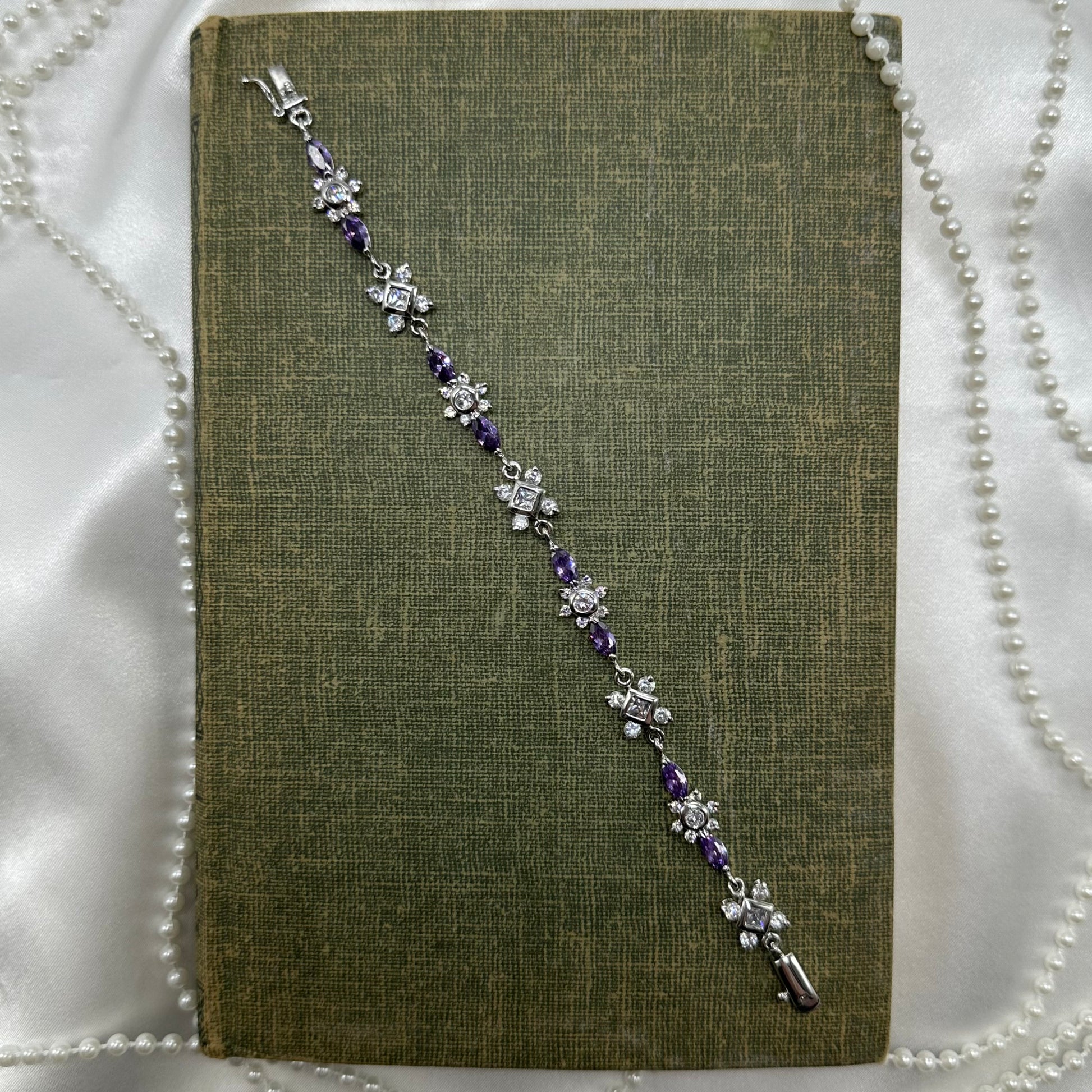 Vintage silver tone bracelet with purple stones and safety clasp.