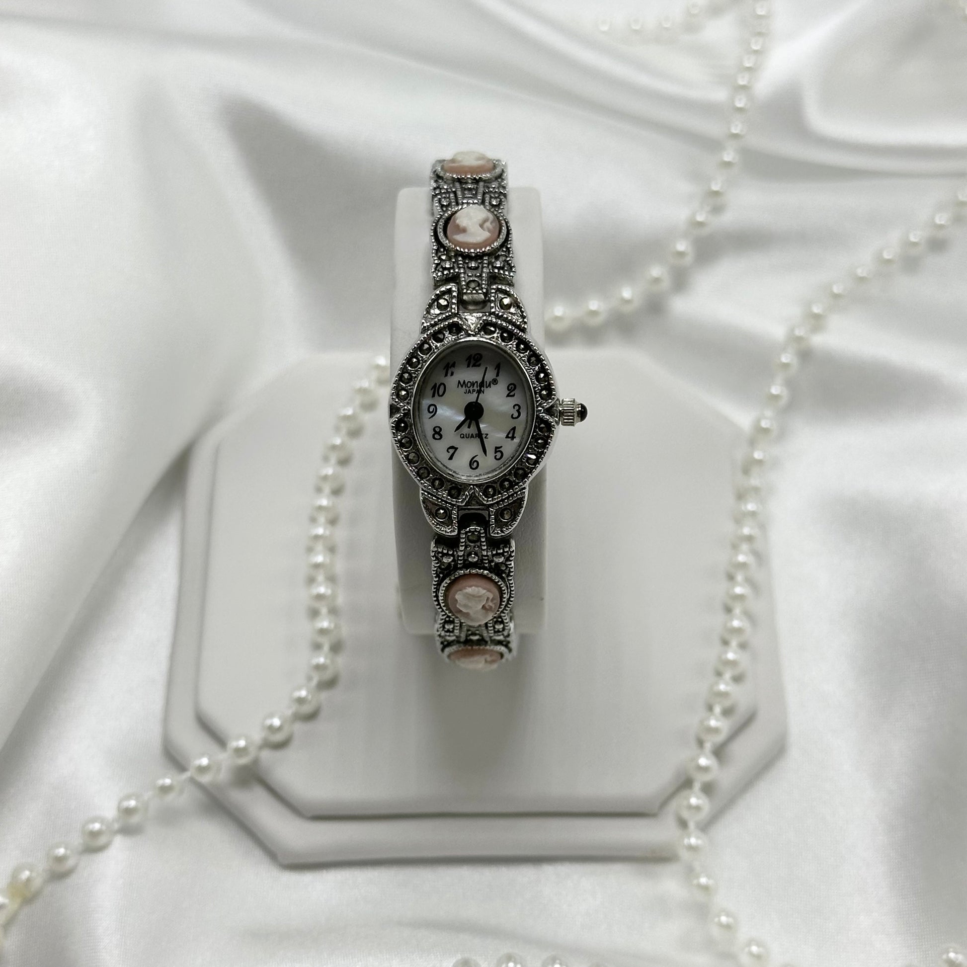 Vintage silver tone cameo watch with mother of pearl dial and blue jewel crown