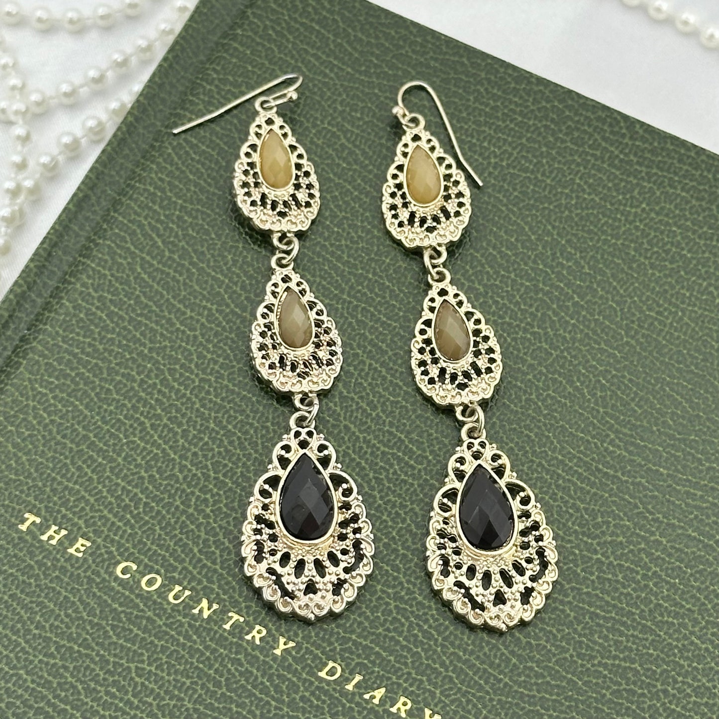 Vintage silver tone long dangle earrings with tan and black stones.