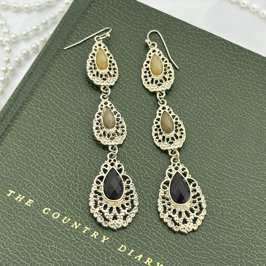 Vintage silver tone long dangle earrings with tan and black stones.