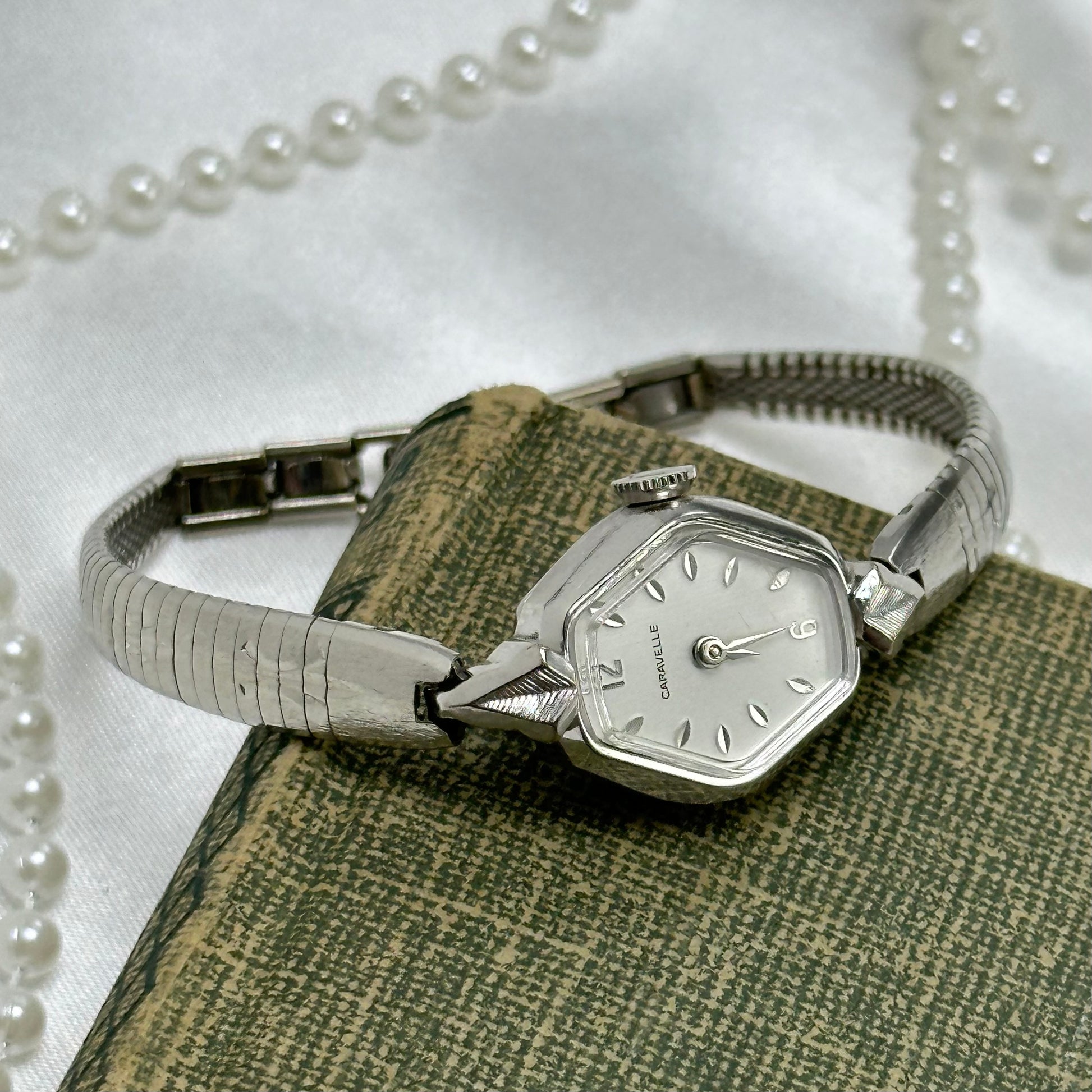 Vintage silver tone manual winding Caravelle by Bulova watch from the 1970's with detailed swirl pattern band.&nbsp;Watch comes with original C crown.