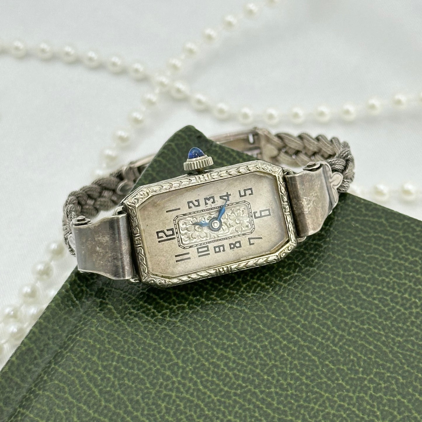 Vintage silver tone manual winding art deco watch with original band, blue hands and blue jewel crown from the 1930's.