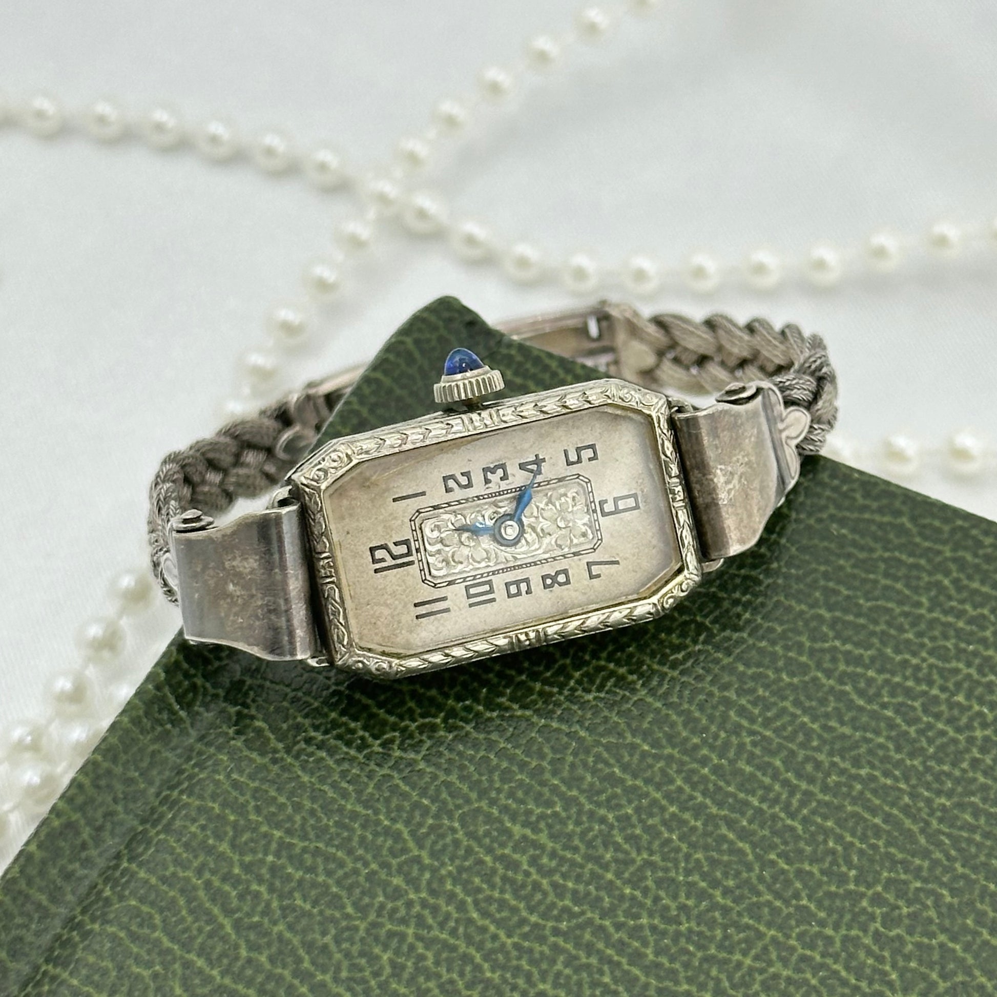 Vintage silver tone manual winding art deco watch with original band, blue hands and blue jewel crown from the 1930's.