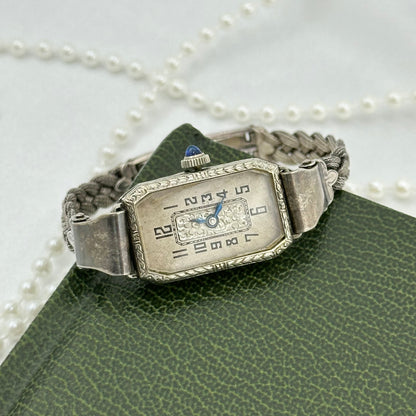 Vintage silver tone manual winding art deco watch with original band, blue hands and blue jewel crown from the 1930's.
